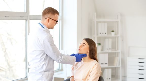 Médico tocando a garganta de paciente